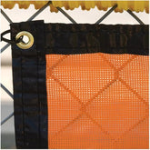 Close-up of a chain link fence featuring an orange mesh, highlighting the texture and pattern of the materials used.